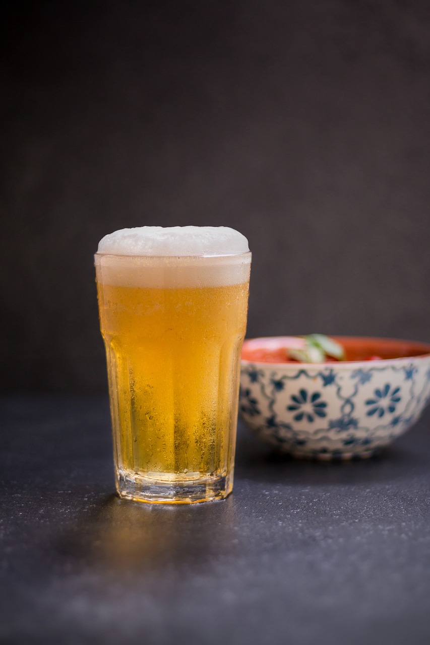 a glass of beer next to a bowl of food, inspired by Kanō Shōsenin, shutterstock, shin hanga, mid shot portrait, slush, miniature product photo
