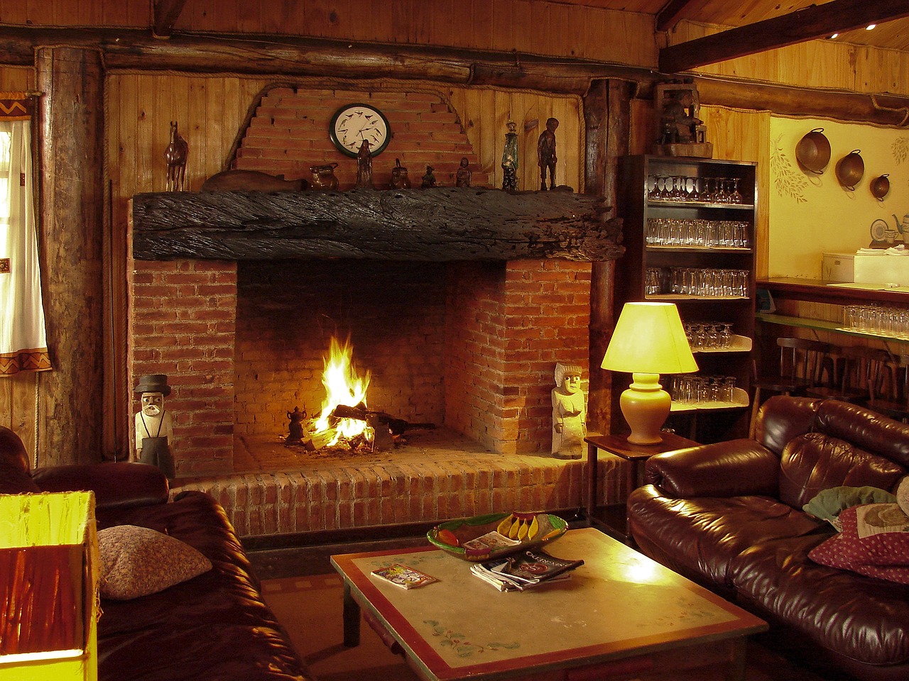 a living room filled with furniture and a fire place, pixabay, brick, hut, koyaanisqatsi, wood paneling