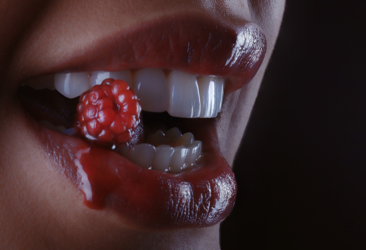 a close up of a person's mouth with a raspberry on it, by Adam Marczyński, 3 d cg, woman vampire, photographed on ektachrome film, istockphoto