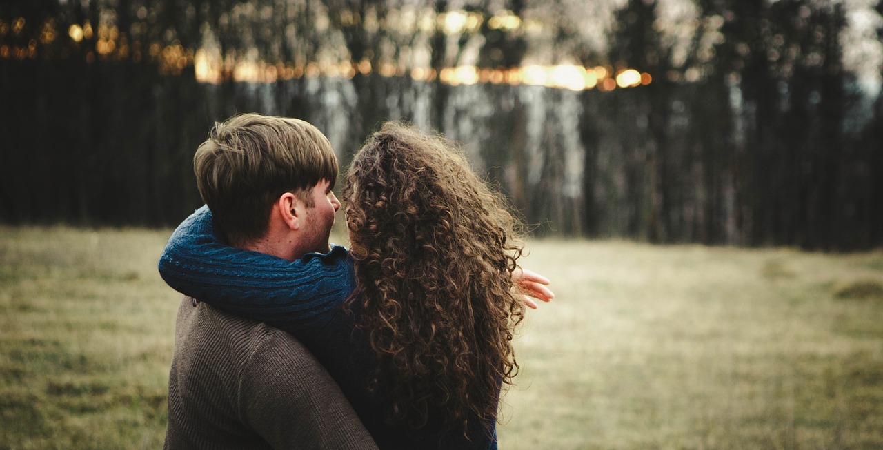 a man and woman embracing each other in a field, tumblr, brown curly hair, header, instagram photo, small