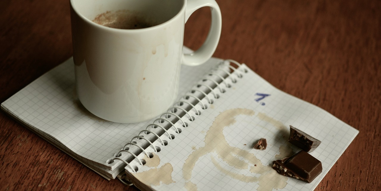 a cup of coffee sitting on top of a notebook, a photo, happening, puke, brown holes, viktoria gavrilenko, messy