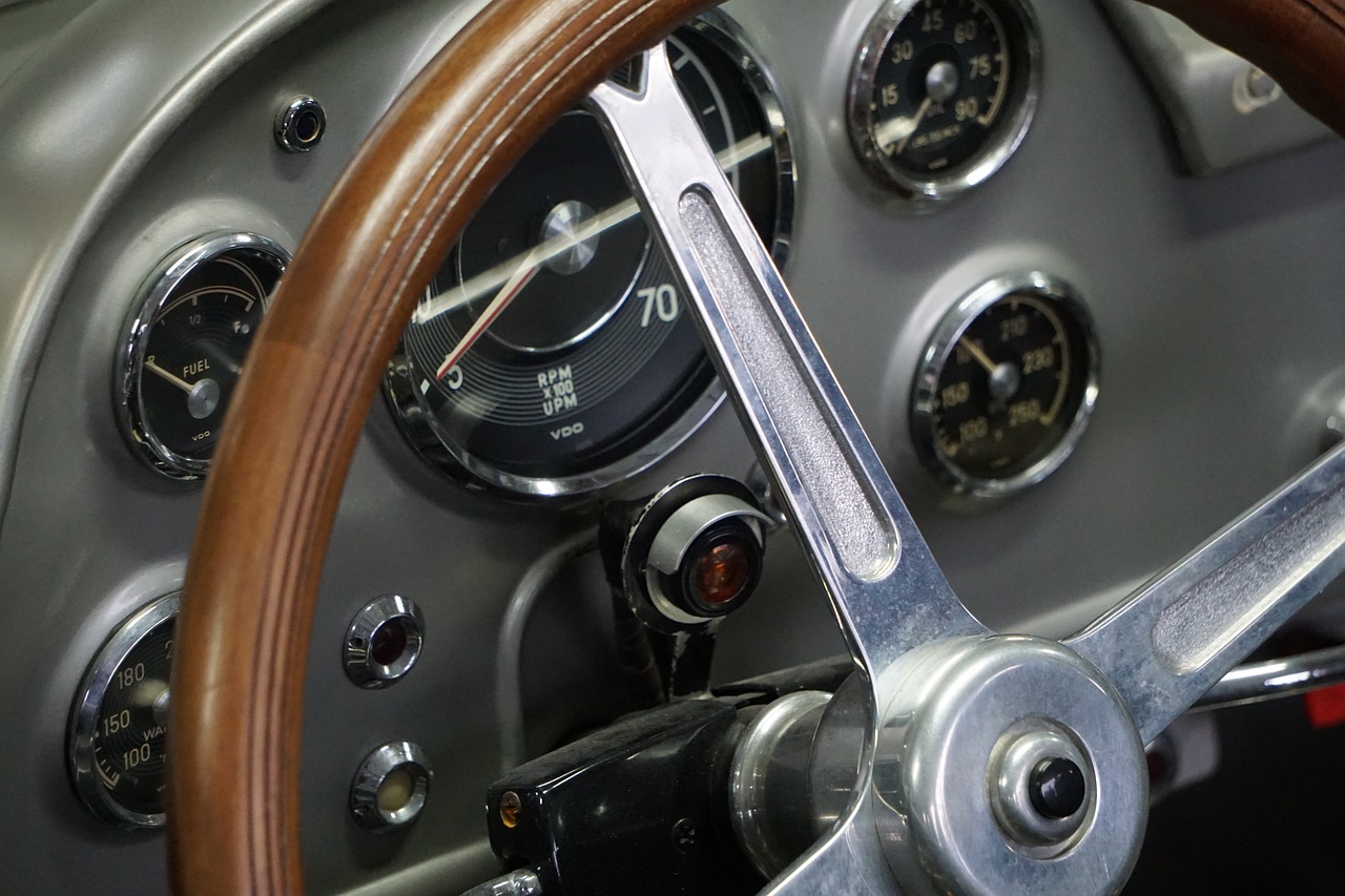a close up of a steering wheel on a car, a portrait, by David Simpson, les automatistes, mechanical accents!, vintage aston martin, smooth tiny details, clear detail