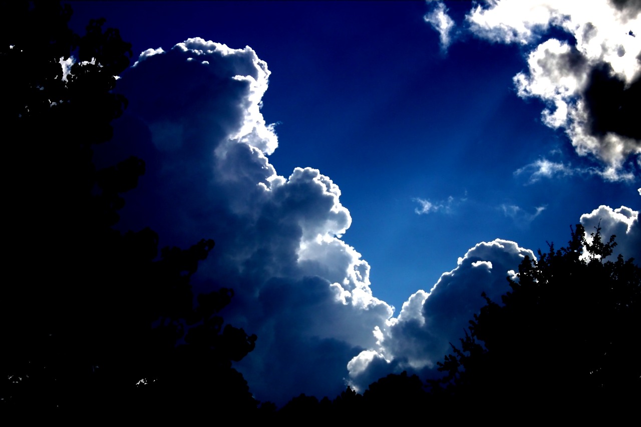 a couple of clouds that are in the sky, by Tom Carapic, flickr, romanticism, back light contrast, dramatic blue lighting, silhouette!!!, severe - looking