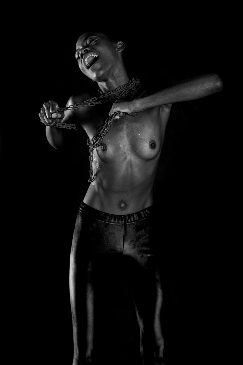 a black and white photo of a man holding a baseball bat, inspired by Peter Basch, featured on cgsociety, art photography, scales covering her chest, thick glowing chains, photo of a black woman, dark. studio lighting