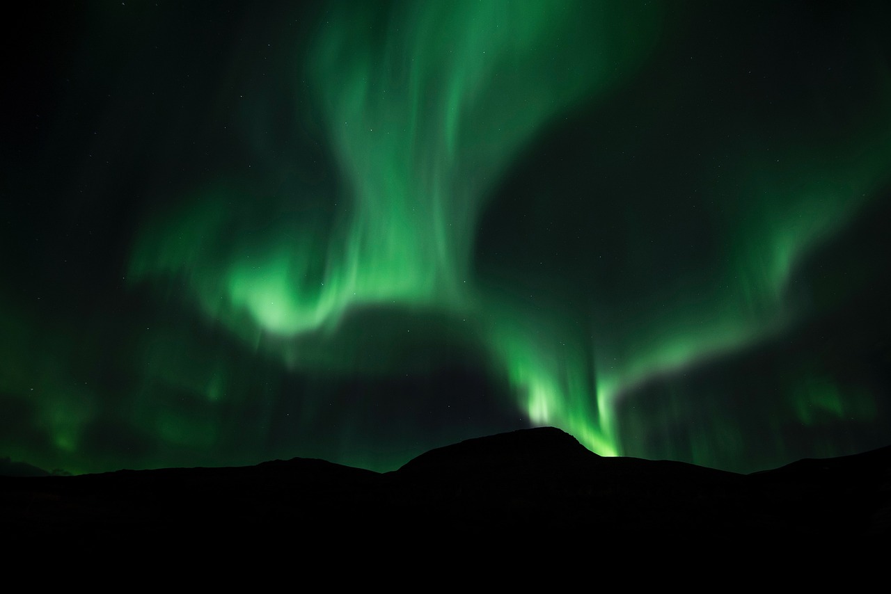 the aurora bore lights up the night sky, by Ejnar Nielsen, pexels contest winner, hurufiyya, beautiful lighting uhd, mountain, whirling, istock