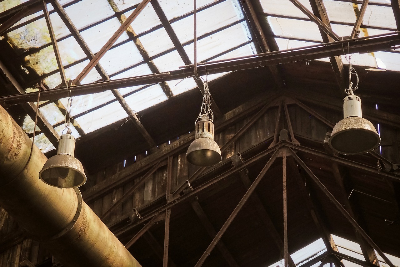 a bunch of bells hanging from the ceiling of a building, by Mathias Kollros, [[empty warehouse]] background, rust, peaked wooden roofs, blog-photo