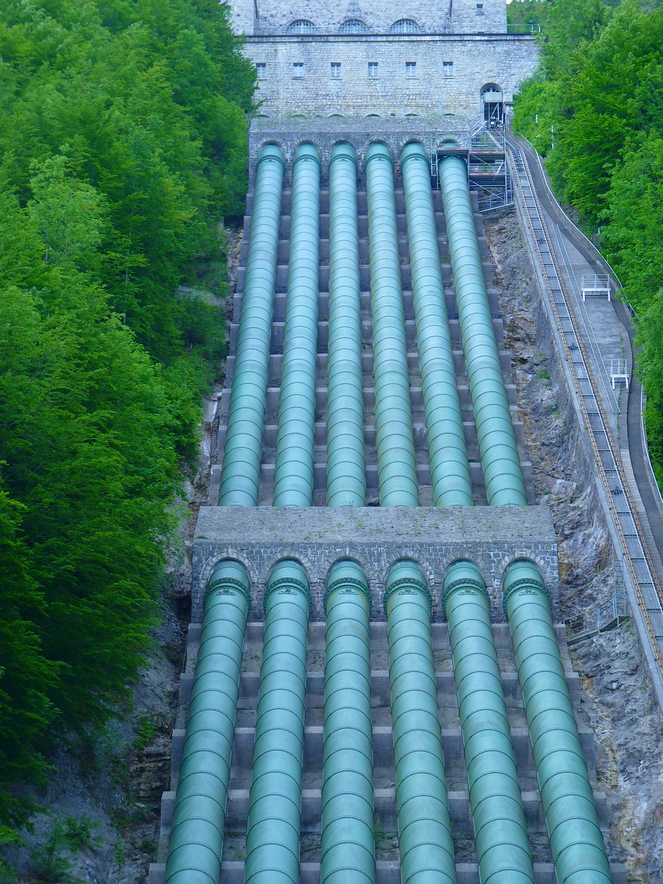 a bunch of pipes that are going down a hill, by Erwin Bowien, flickr, renaissance, water reservoir, gunma prefecture, green water, aqueducts