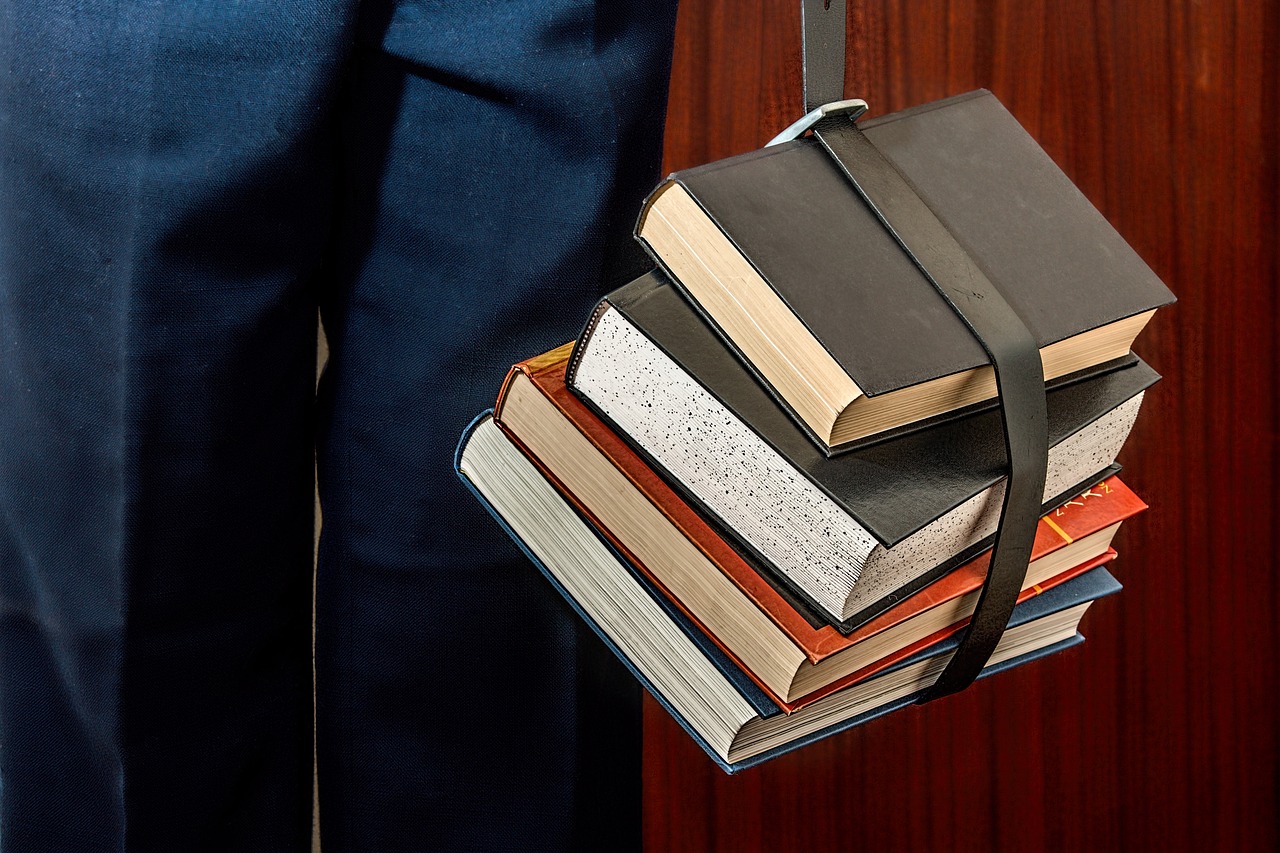 a man holding a bunch of books in his hand, a stock photo, unilalianism, [ [ hyperrealistic ] ], straps, platforms, mooc