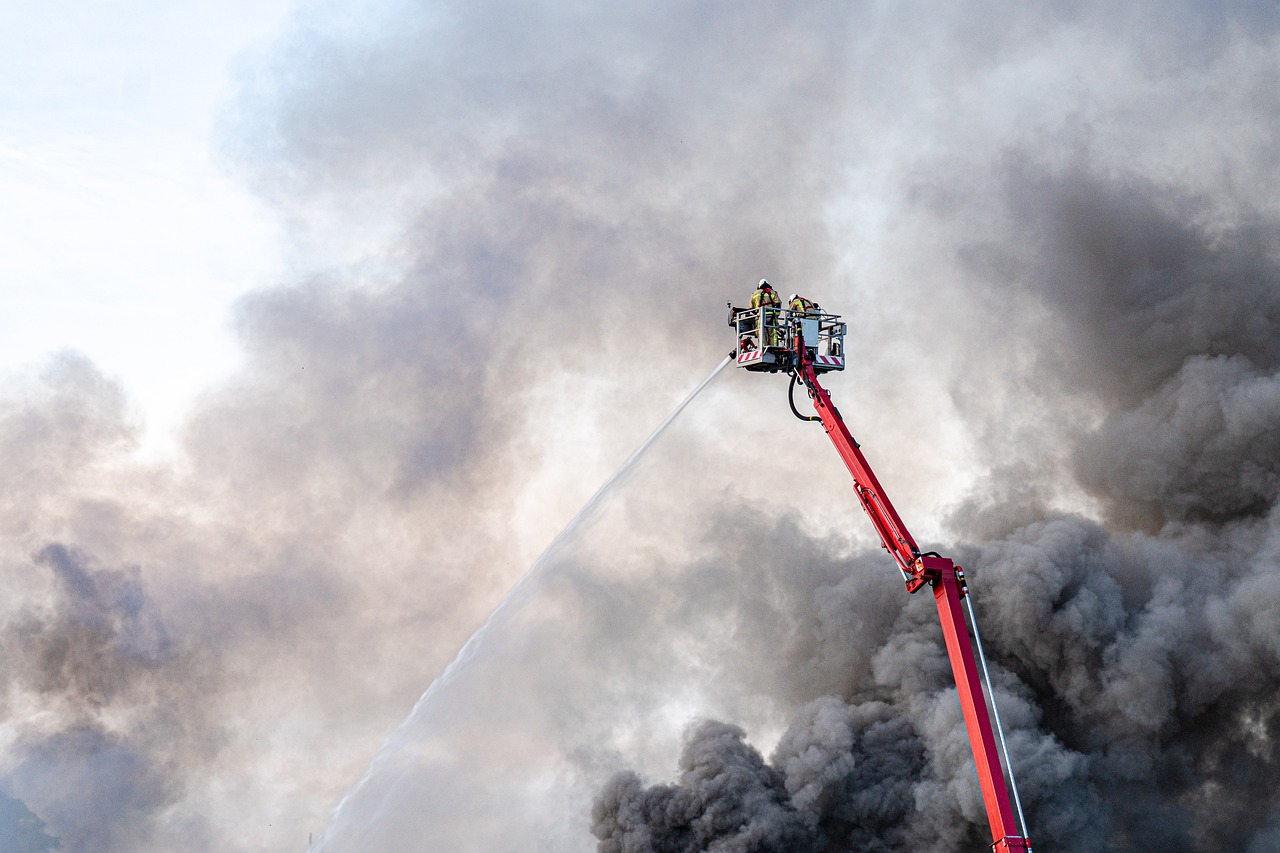 a fire truck spraying water on a large fire, a picture, by Jan Rustem, pexels, auto-destructive art, seen from below, portrait n - 9, demolition, in clouds of smoke