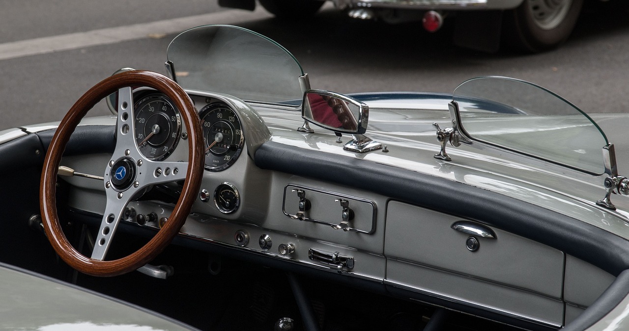 a close up of a steering wheel on a car, by Jay Hambidge, unsplash, retrofuturism, mercedes, spitfire, glass, convertible