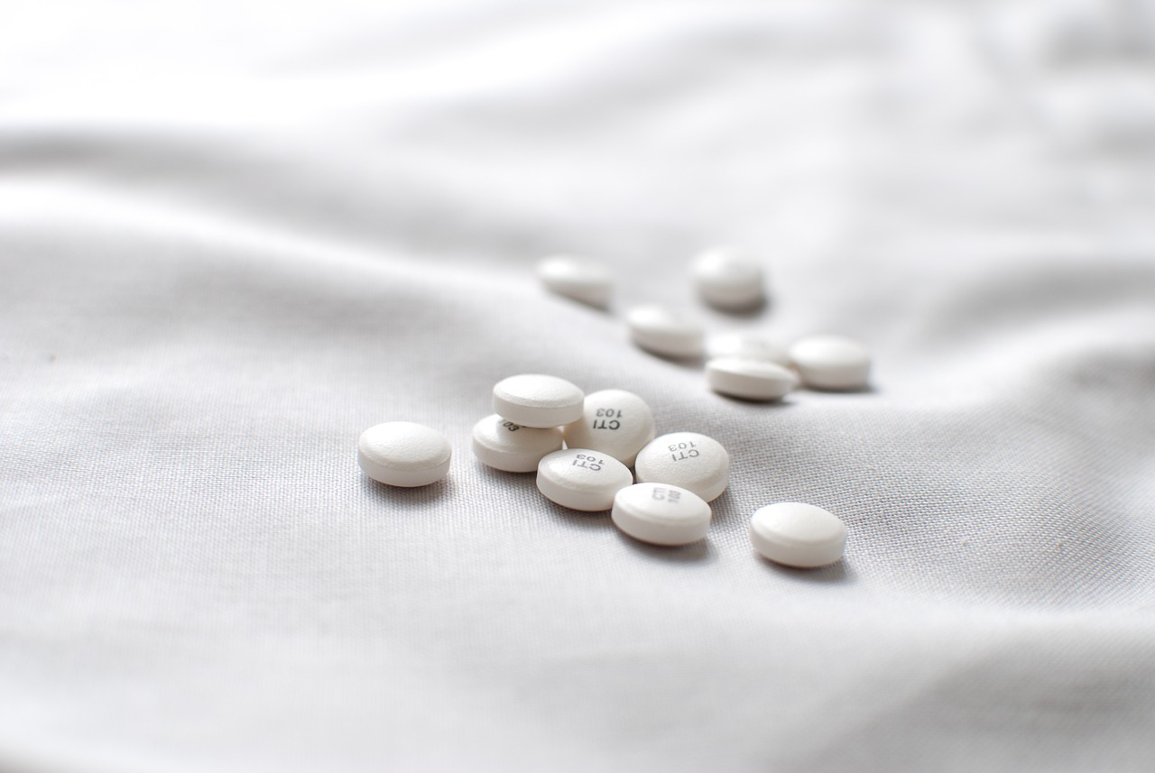 a bunch of pills sitting on top of a white sheet, antipodeans, wearing white silk, 33mm photo