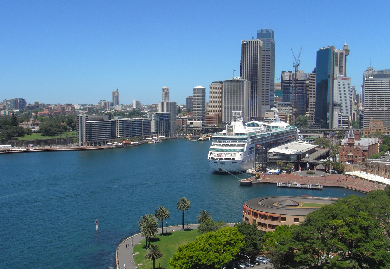 a cruise ship docked in a harbor with a city in the background, inspired by Sydney Carline, hurufiyya, view from high, viewed from the harbor, no crop, photo taken with provia