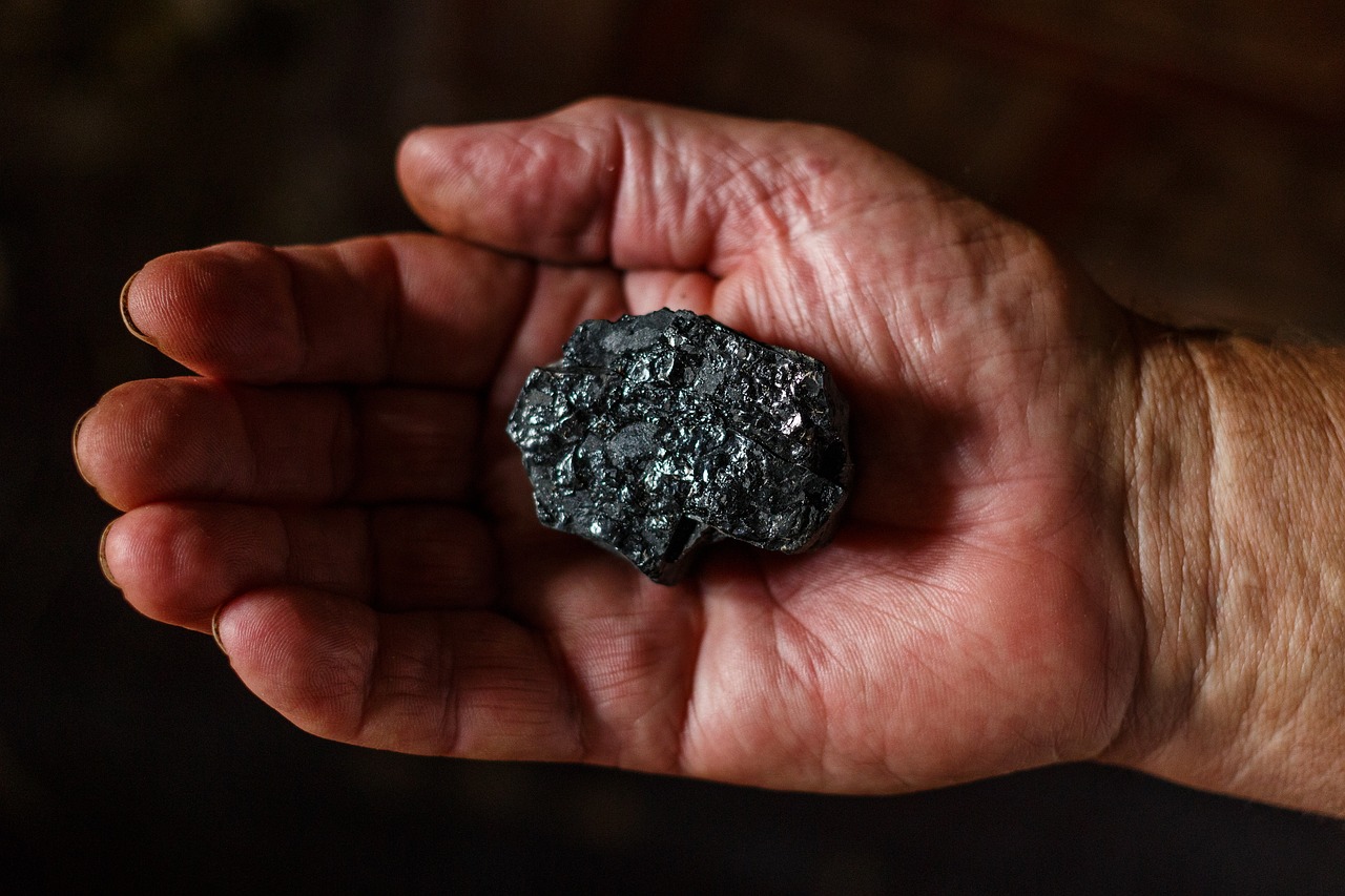 a person holding a piece of metal in their hand, by Kazimierz Wojniakowski, unsplash, high resolution coal texture, ( ultra realistic ), istock, close up shot of an amulet