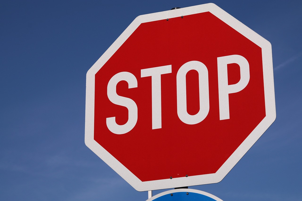 a red stop sign sitting next to a blue street sign, a picture, shutterstock, grey, top, watch photo, brown