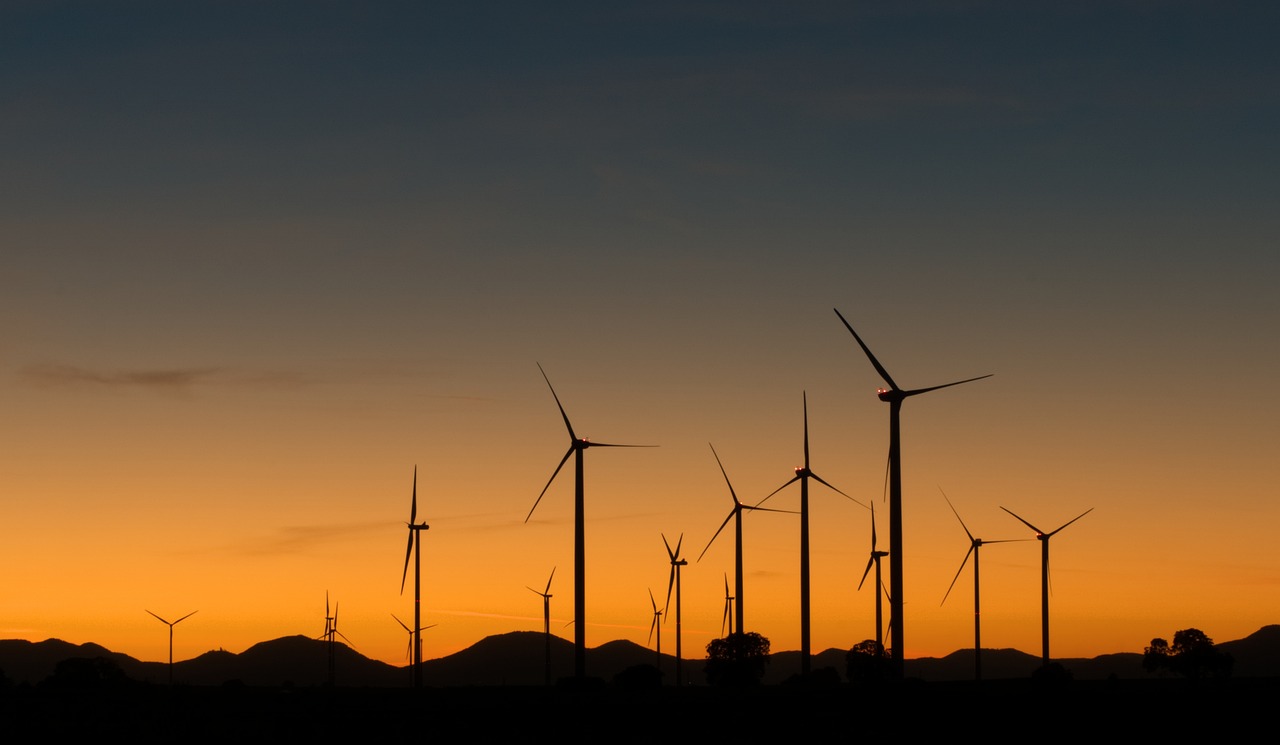 a group of windmills in a field at sunset, by Edwin Georgi, precisionism, profile shot, mountain, maintenance photo, 1128x191 resolution