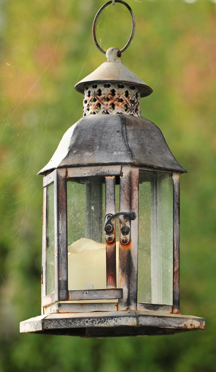 a bird feeder with a bird inside of it, by Tom Carapic, pixabay, folk art, lantern candle, beautiful aged and rustic finish, with cobwebs, full - view