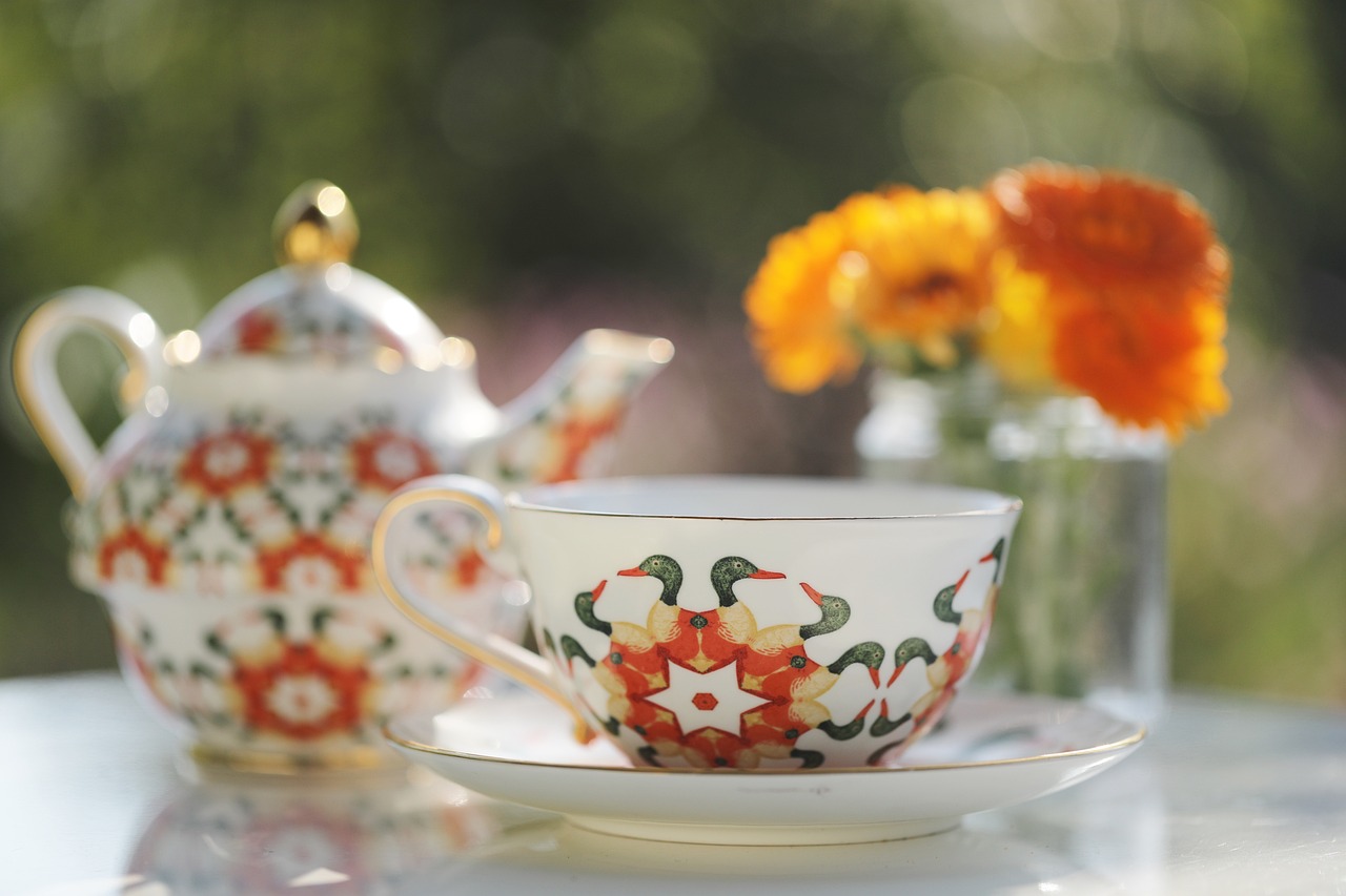a close up of a cup and saucer on a table, inspired by William Morris, marigold flowers, assam tea garden setting, anton fedeev, moroccan tea set