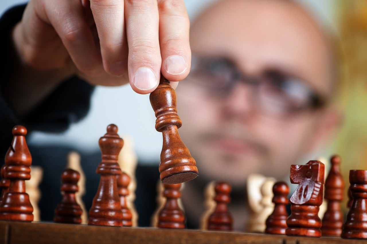 a close up of a person playing a game of chess, a stock photo, precisionism, closeup portrait of an artificer, with a wooden stuff, high details photo