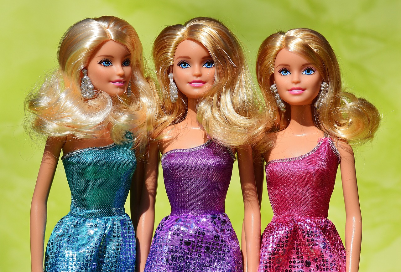 a group of three barbie dolls standing next to each other, a picture, by Gwen Barnard, shutterstock, long blonde hair and blue eyes, purple and blue and green colors, stock photo, sparkling in the sunlight