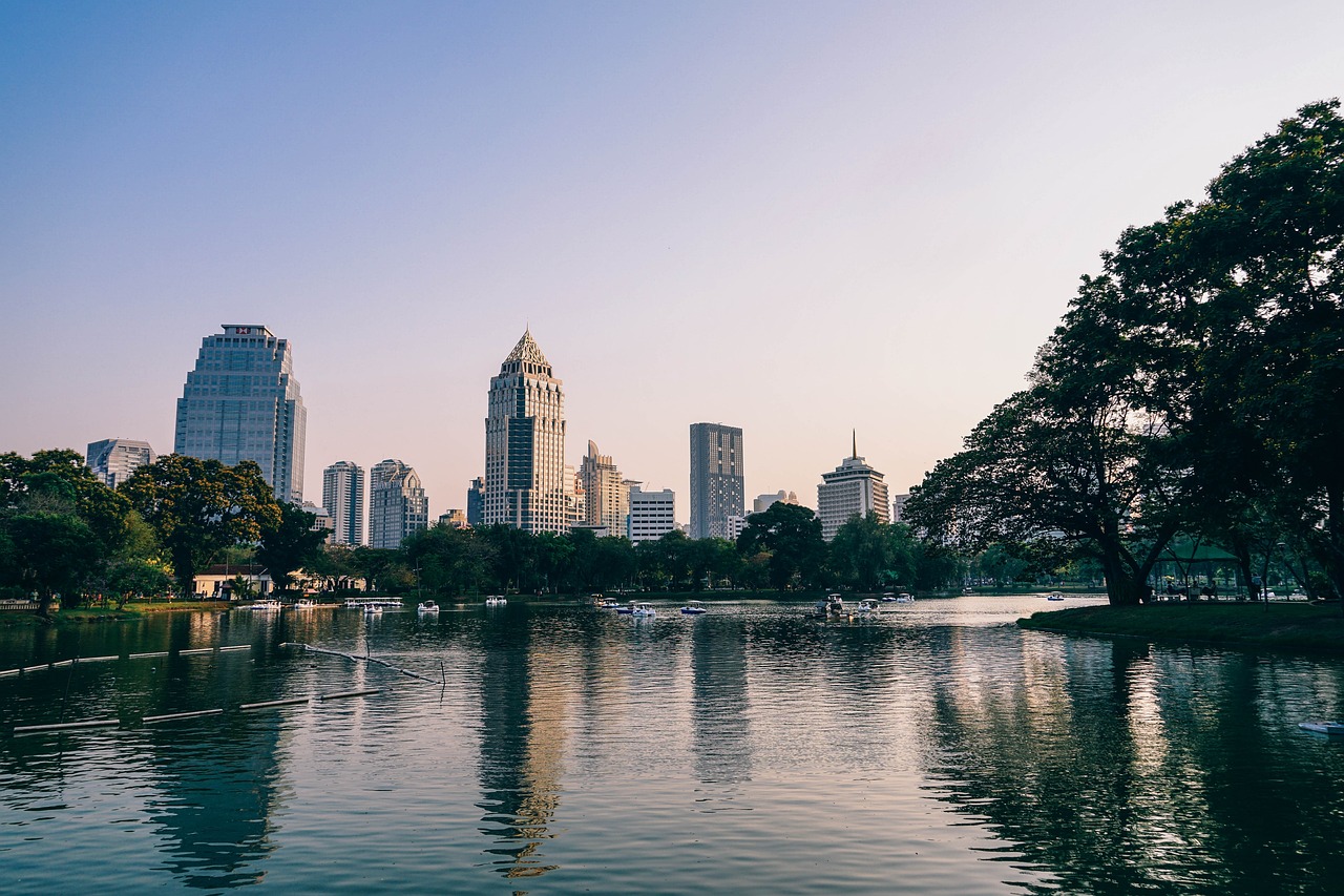 a body of water with buildings in the background, a picture, shutterstock, sangyeob park, cinematic morning light, very low quality, in style of thawan duchanee