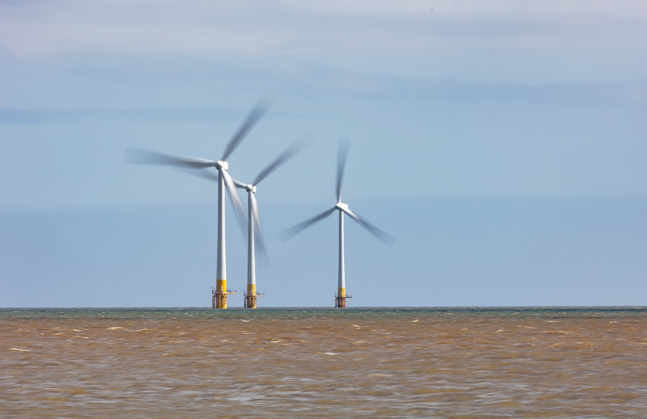 a group of wind turbines sitting on top of a body of water, a portrait, by Edward Corbett, shutterstock, hull, telephoto shot, three views, slightly blurred