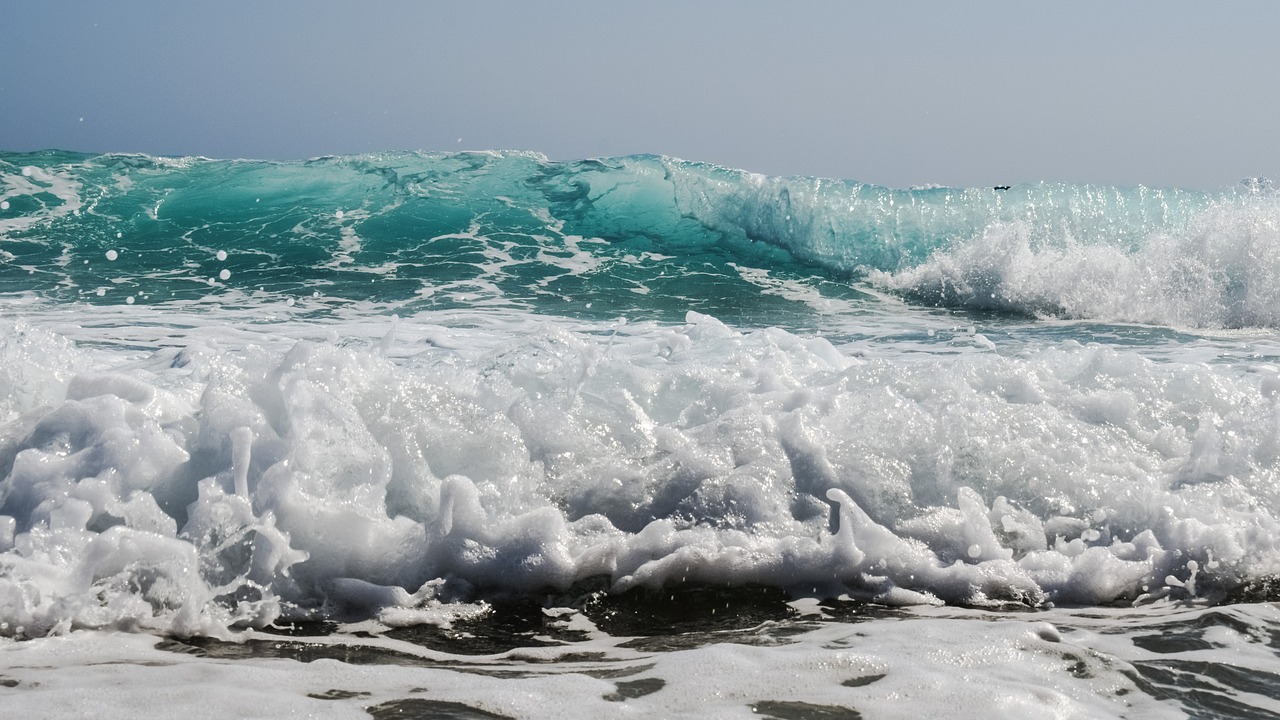 a man riding a wave on top of a surfboard, by Matthias Weischer, pexels, plasticien, sea foam, glistening seafoam, charybdis, blue sand