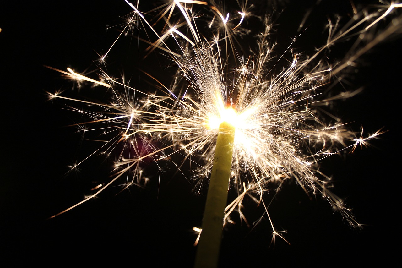 a close up of a sparkler in the dark, istockphoto, celebrating a birthday, shot from below, sparkles and glitter