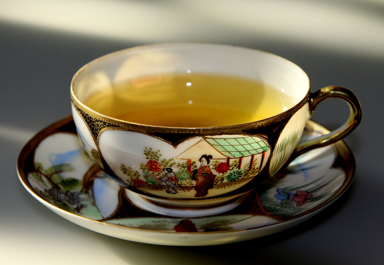 a cup of tea sitting on top of a saucer, inspired by Kanō Shōsenin, flickr, closeup portrait shot, finely detailed, reflection, a brightly colored