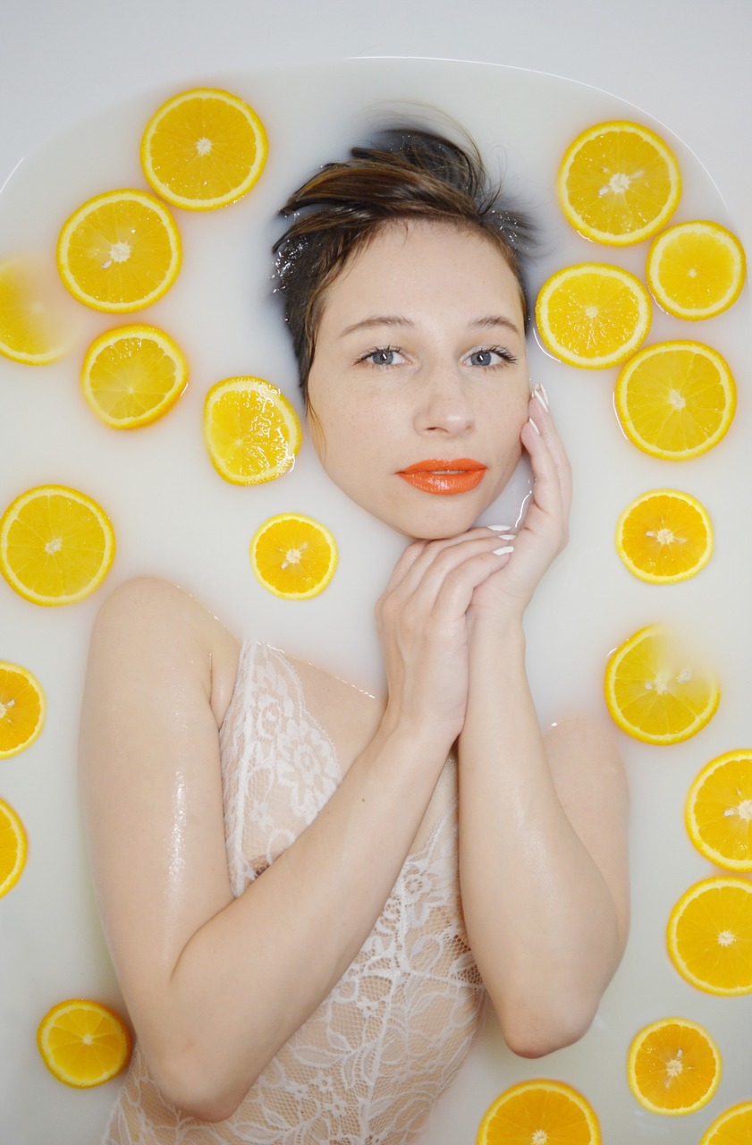 a woman laying in a bath filled with orange slices, a portrait, inspired by Bert Stern, pexels, sleek yellow eyes, anna nikonova aka newmilky, milk - bath effect, clean 4 k