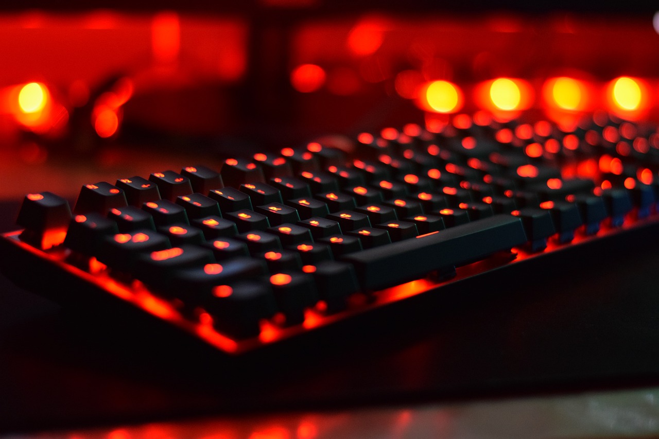 a computer keyboard sitting on top of a desk, by Aleksander Kobzdej, red and orange glow, 4k vertical wallpaper, mmo, bottom angle