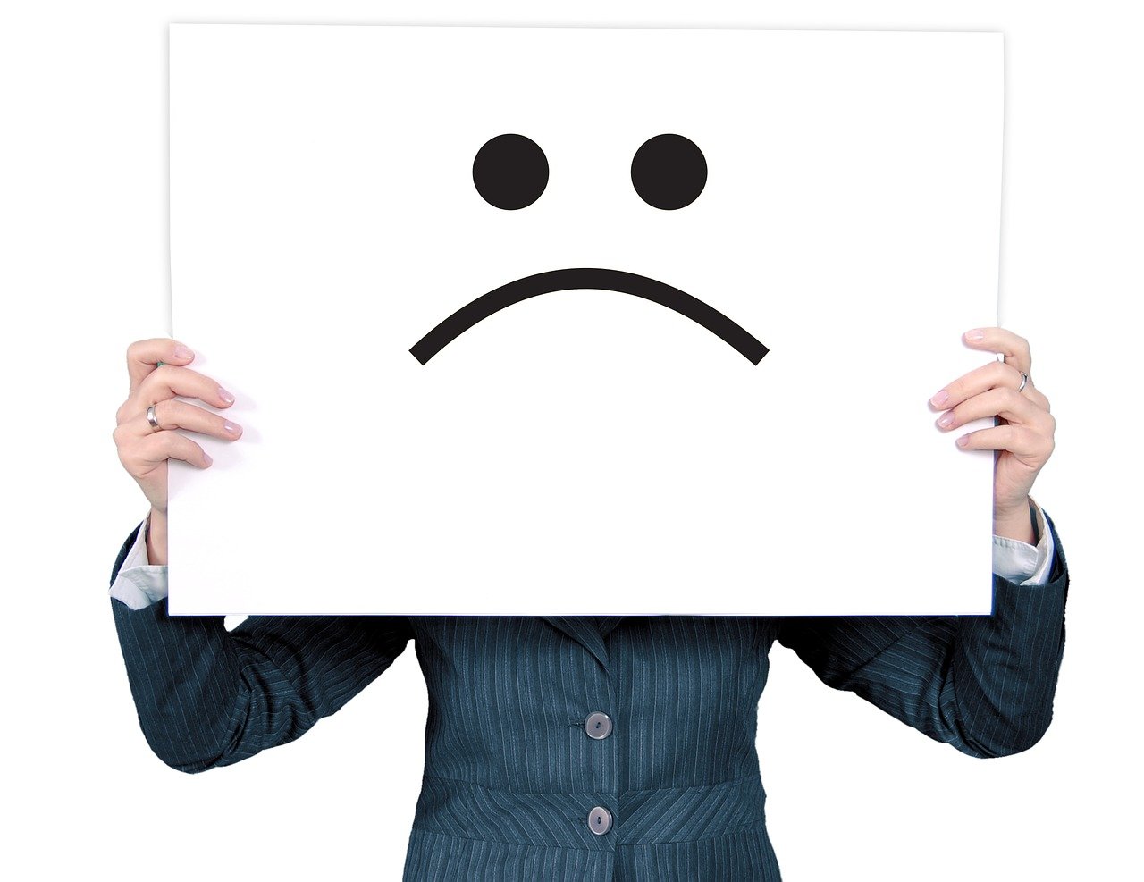 a woman holding a sign with a sad face drawn on it, by Itō Seiu, pixabay, isolated on white, emotionless, dingy, closeup photograph