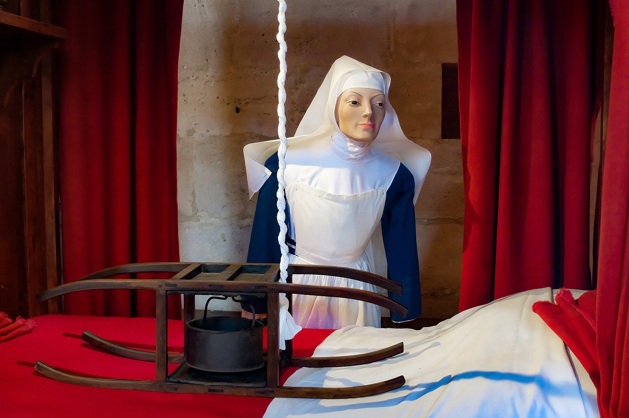 a statue of a nun standing next to a bed, inspired by Jean Fouquet, flickr, surgical impliments, on a mannequin. high quality, located in a castle, closeup photo