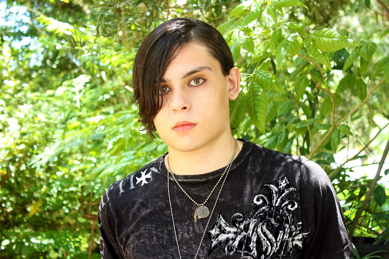 a close up of a person with a necklace on, an album cover, inspired by Kristian Kreković, flickr, cute emo guy, in front of a forest background, very beautiful goth top model, jack white