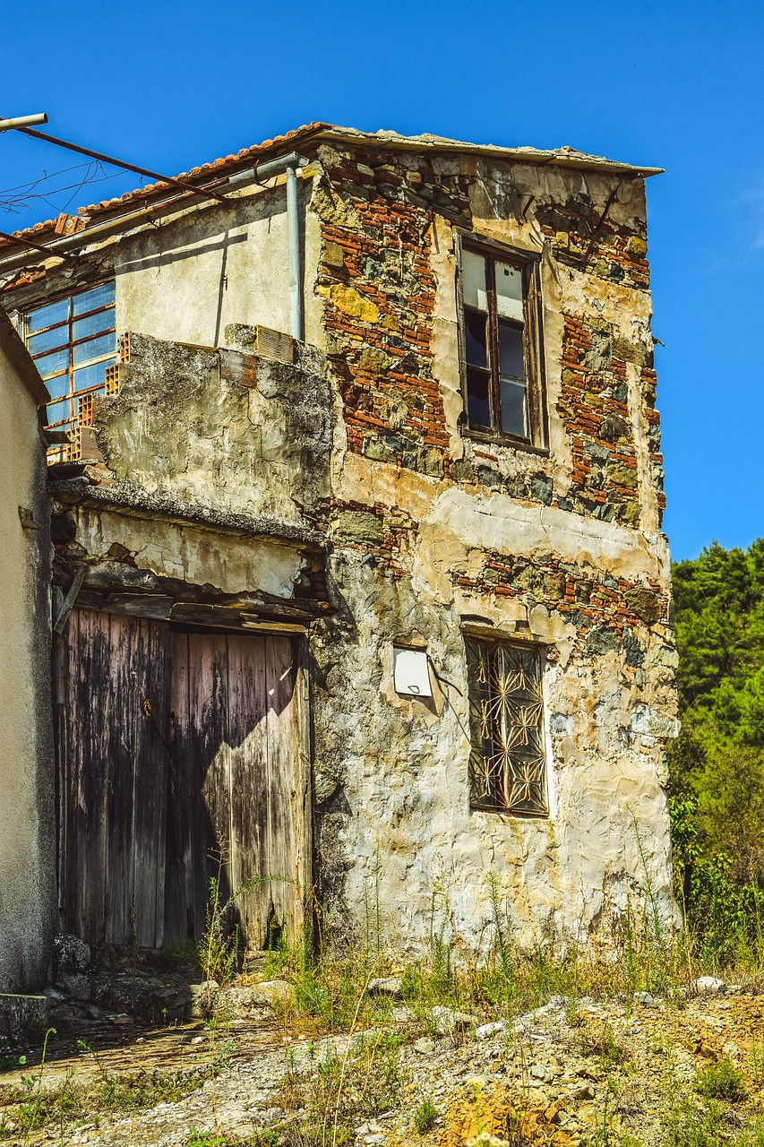 an old building sitting on the side of a dirt road, by Cedric Peyravernay, shutterstock, smashed wall, traditional corsican, decaying rich colors!, standing outside a house