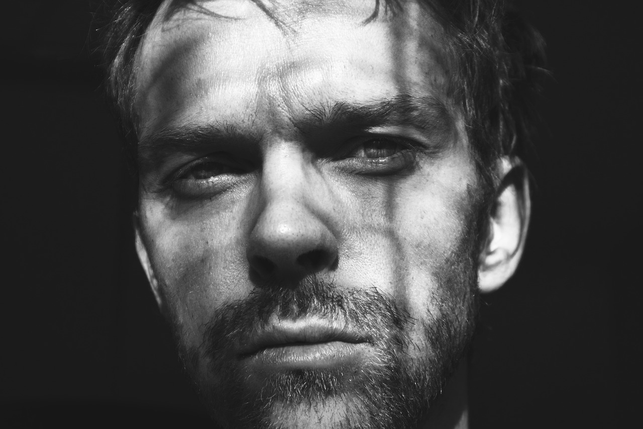 a black and white photo of a man with a beard, a black and white photo, by Matthijs Naiveu, unsplash, bauhaus, green goblin portrait, orelsan, hugh laurie, face is brightly lit