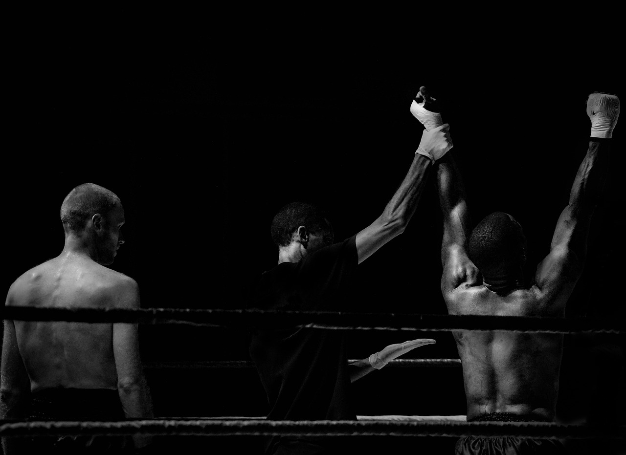 a group of men standing next to each other in a boxing ring, a black and white photo, pexels contest winner, with his back to the viewer, winning award photo, fisting, phone wallpaper