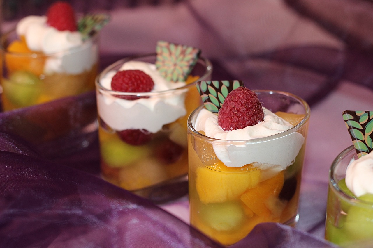 a group of desserts sitting on top of a table, inspired by Kanō Tan'yū, flickr, renaissance, tropical fruit, jello, whipped cream, closeup photo