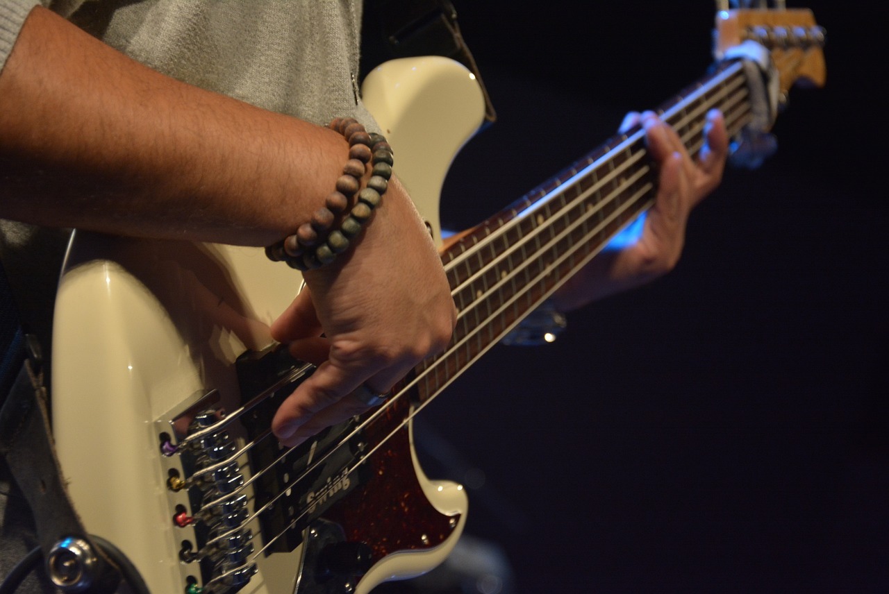 a close up of a person playing a guitar, a picture, by Tom Carapic, wearing two silver bracelets, bassist, repetitiveness, cream
