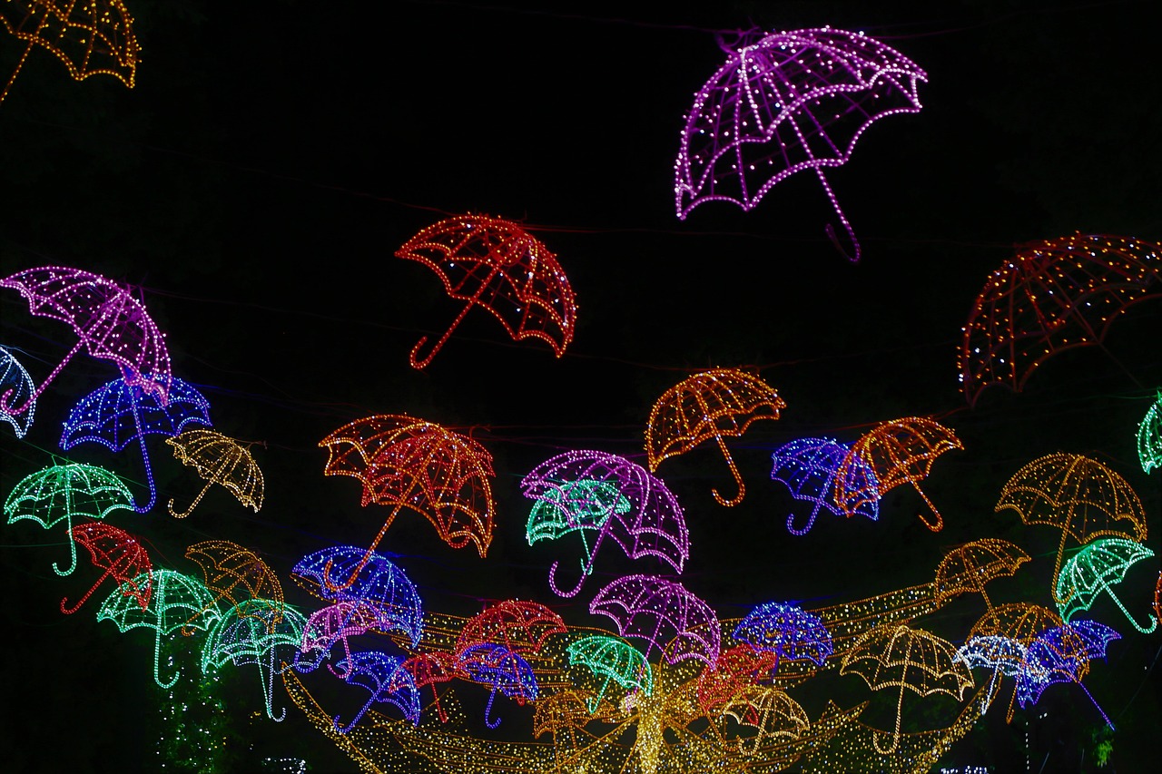 a bunch of umbrellas are lit up in the dark, a photo, christmas lights, bright neon signs, low angle photo, wings made of light