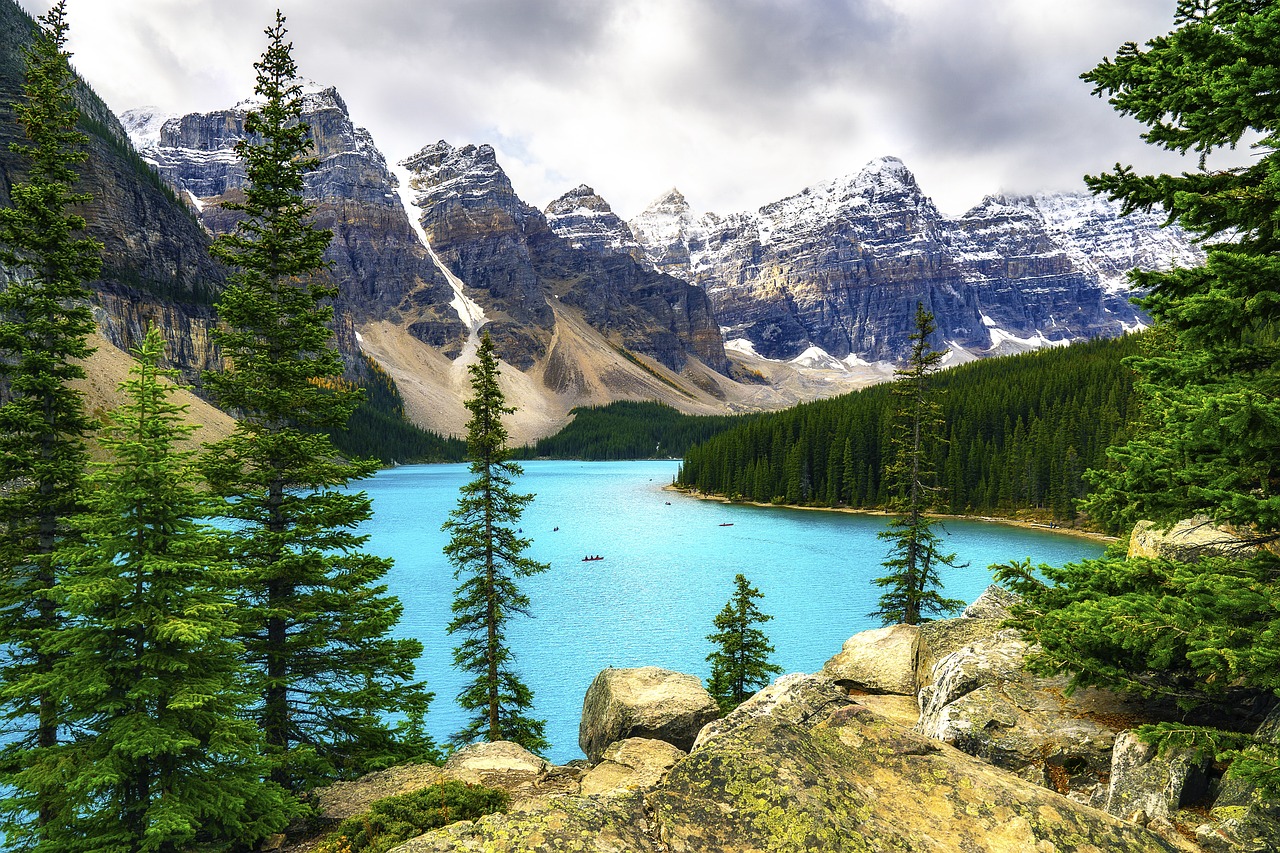 a large body of water surrounded by trees, a photo, by Whitney Sherman, shutterstock, banff national park, vibrant but dreary blue, bakelite rocky mountains, high definition background