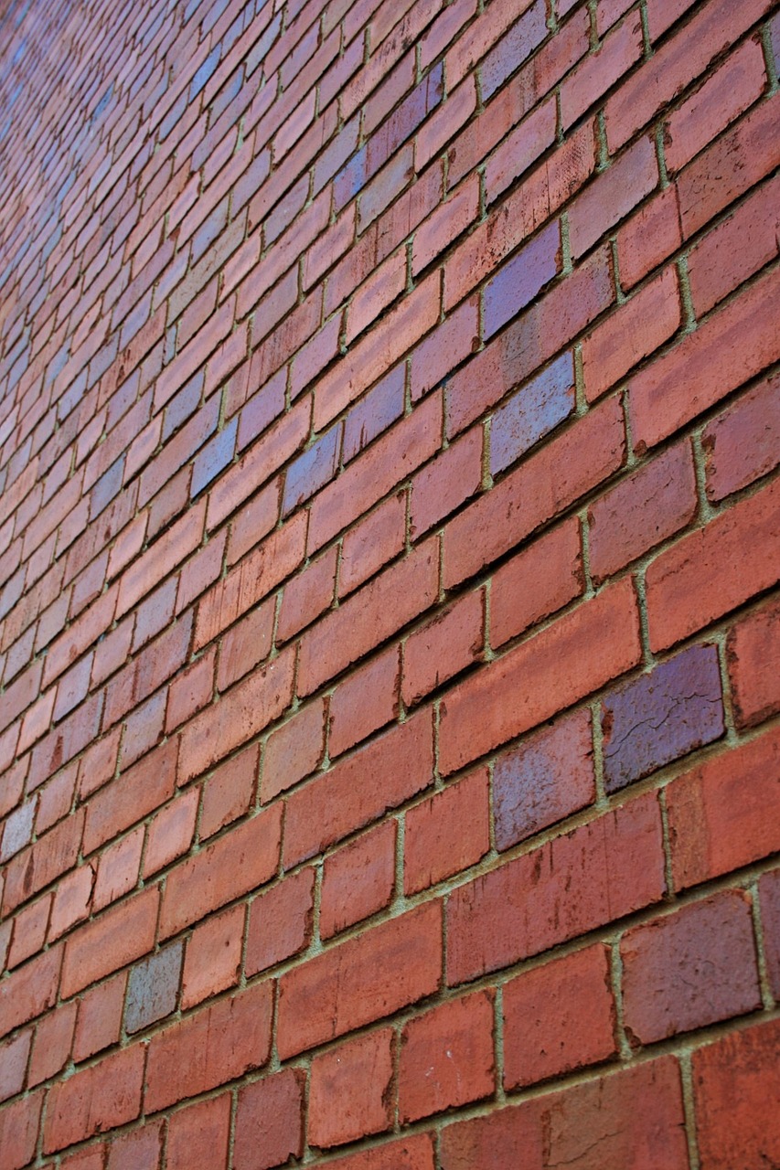a red brick wall with a blue sky in the background, a picture, modernism, detailed zoom photo, outdoor photo, angled, construction