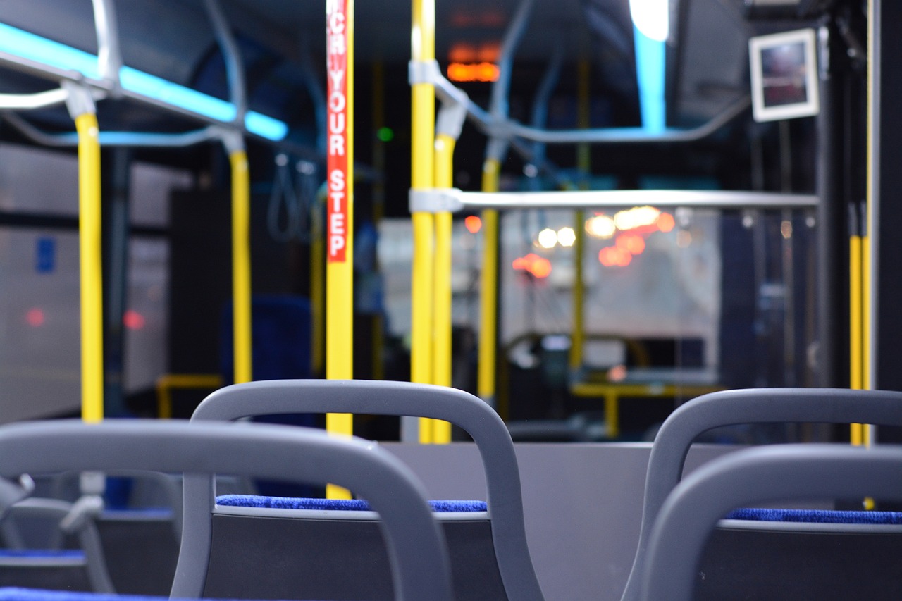 a view of the inside of a public transit bus, a portrait, shutterstock, blue neon details, set photo, two plastic chair behind a table, rack focus
