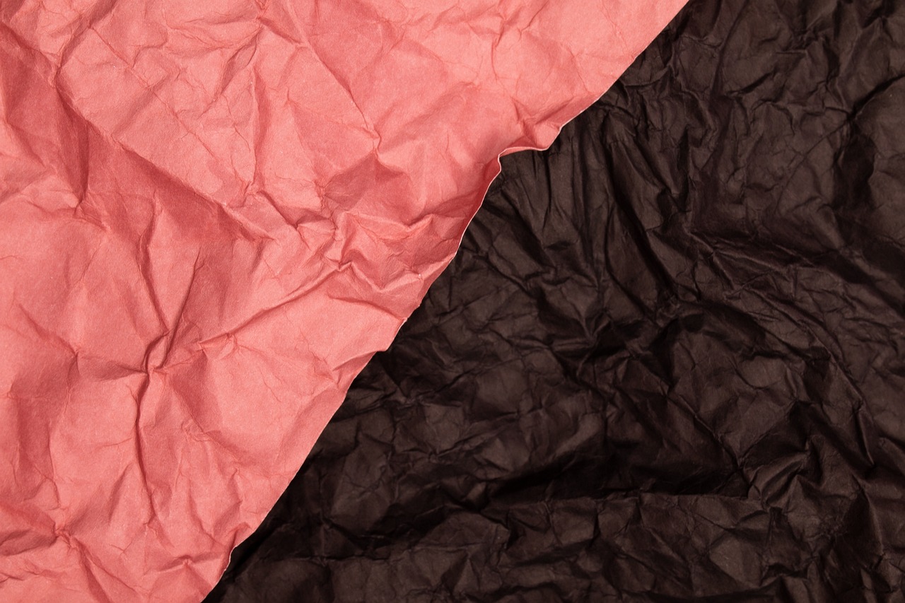 a close up of a pink and black piece of paper, a stock photo, by Edward Bailey, shutterstock, wrinkled, both bright and earth colors, packshot, two colors