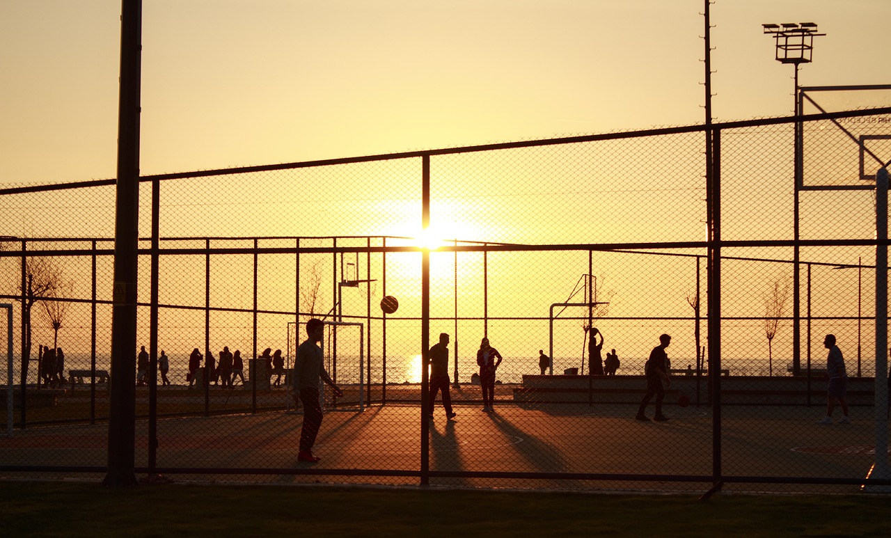 a group of people playing a game of basketball, by Hiroshi Honda, pexels, conceptual art, sunset kanagawa prefecture, tennis court, netting, hot summer sun