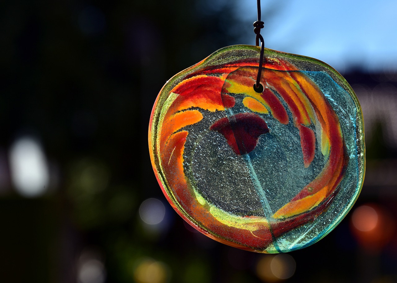 a colorful glass sun catcher hanging from a string, by Jan Rustem, flickr, softly backlit, enso, poppy, swirly