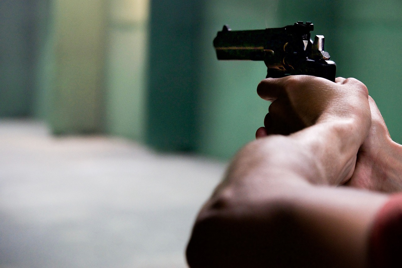 a person holding a gun in their hand, a picture, by Matteo Pérez, training, background, close to the camera, indoor shot