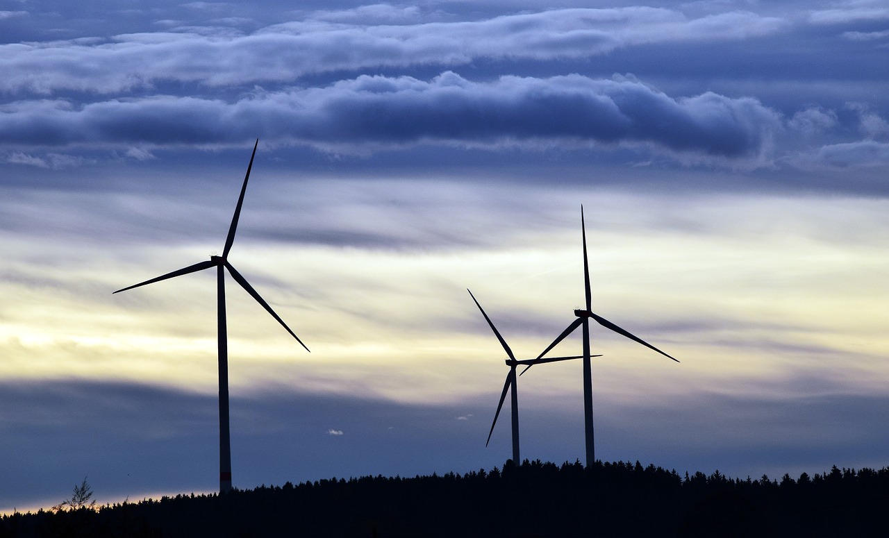 three wind turbines are silhouetted against a cloudy sky, by Jesper Knudsen, precisionism, blue energy, evening lighting, istockphoto, nordic