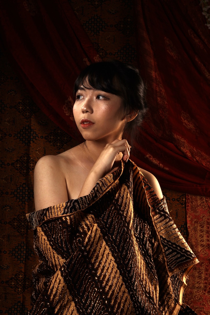 a woman is wrapped up in a blanket, inspired by Gao Kegong, hyperrealism, 1920s studio lighting, batik, solo photoshoot, dark drapery