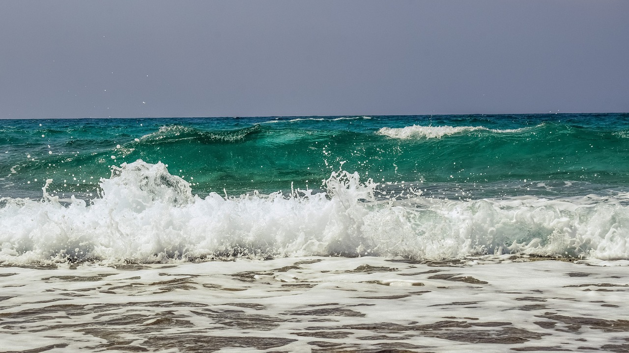 a man riding a wave on top of a surfboard, a picture, by Mathias Kollros, shutterstock, mediterranean beach background, glistening seafoam, cyprus, full of greenish liquid