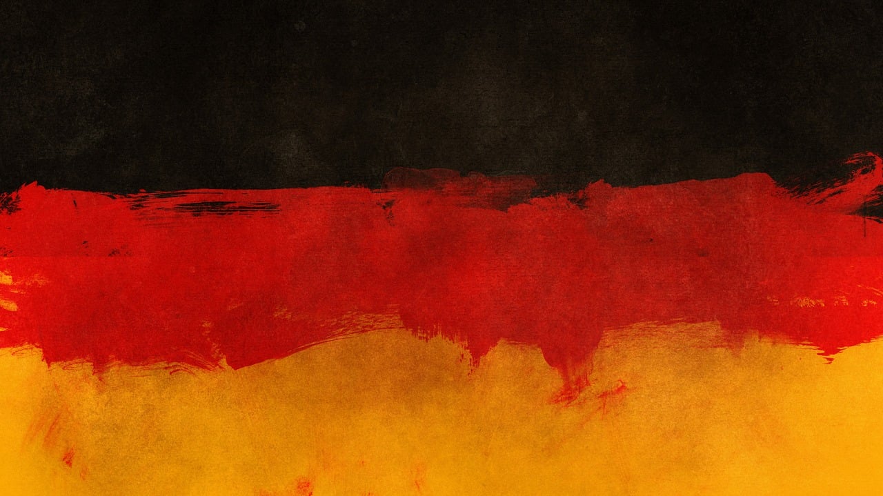 a red and yellow painting on a black background, a digital painting, trending on pixabay, german romanticism, flags, black watercolour, germany. wide shot, textured parchment background